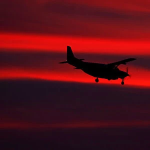 A small propeller plane lands after sun set in San Diego, California