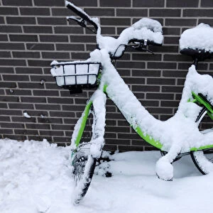 A snow-covered bike is seen on a street in Vincennes near Paris, France