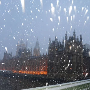 Snow falls around The Houses of Parliament in central London