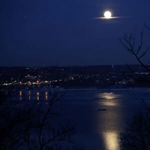 The full Snow moon rises above the Hudson River and the town of Irvington in