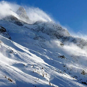The snow sails to the top of a snowy mountain in Saint-Pancrace as winter weather