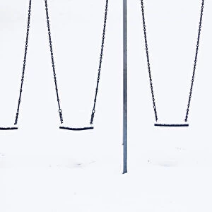 Snow sits on childrens swings at a playground in Lyminge near Folkestone in southern