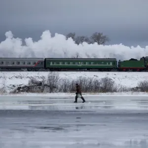 A steam train passes by along a dam outside Ostashkov A steam train passes by along a dam outside Ostashkov