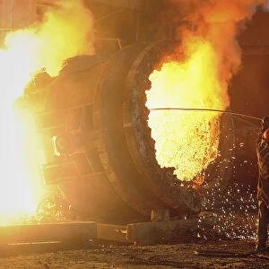 A steel worker operates a furnace at a steel manufacturing plant in Hefei