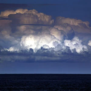 A storm cloud can be seen behind a yacht as it sails off the coast of Sydney