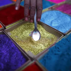 A street vendor spreads vermilion powder used for worship during the Tihar festival in