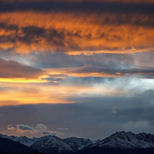The summits of snow covered mountains are silhouetted during sunset in Innsbruck