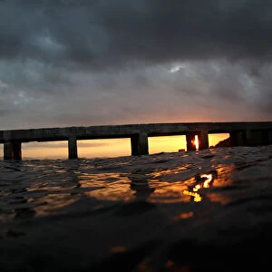 The sun rises behind a pier on the Guanabara Bay in Rio de Janeiro