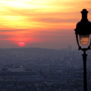 The sun rises as small-particle haze hangs above the skyline in Paris