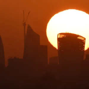 The sun is seen rising over skyscrapers in the City of London financial district in