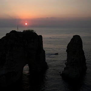 The sun sets behind the Raouche Rocks in Beirut