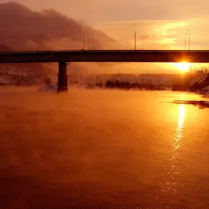 The sun sets over the Yenisey River near the hydroelectric power station by the town