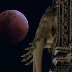 A super blood blue moon is seen behind an elephant statue during an eclipse at a temple