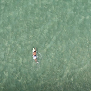 A surfer swims at Barra da Tijuca beach in Rio de Janeiro