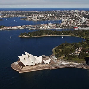 The Sydney Opera House is seen in front of some of the eastern suburbs on a sunny