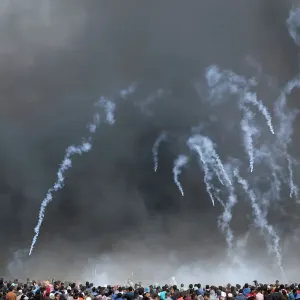 Tear gas canisters are fired by Israeli troops at Palestinian demonstrators during