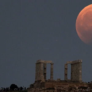 Temple of Poseidon is seen as the moon is partially covered by the Earths shadow