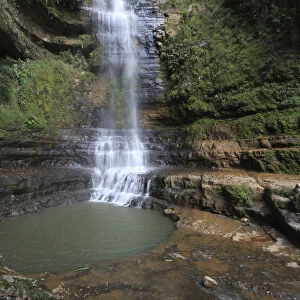 A tourist lies down near a waterfall at the Juan Curi natural park near the municipality
