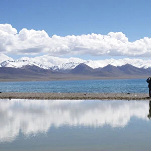 A tourist takes pictures at Namtso lake in the Tibet Autonomous Region