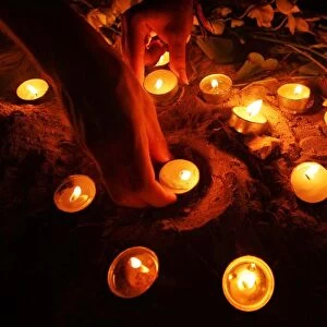 Tourists arrange oil lamps during candle light vigil ceremony on Thai island of Phi Phi