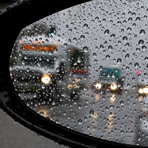 Traffic is reflected in a car mirror as heavy rain falls in San Juan Capistrano