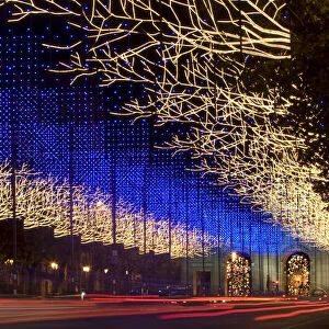 Traffic streams up Alcala street under Christmas lighting in central Madrid