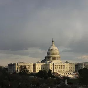 The U. S. Capitol building is seen as the sun begins to set under heavy cloud cover