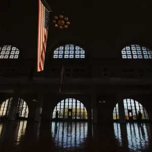 U. S. flag hangs in grand hall of the Ellis Island immigration museum building in New York U. S. flag hangs in grand hall of the Ellis Island immigration museum building in New York