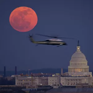 A U. S. Marine Corps helicopter is seen flying through this scene of the full Moon and the U