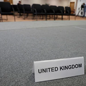 A United Kingdom name card lies on a stage inside the empty British press conference room