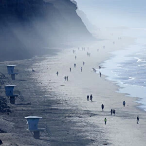 An unusually warm November day brings people to the Torrey Pines State Beach in San Diego