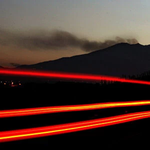 A vehicle passes along a highway as smoke is emitted from the Galeras volcano in Chachagui