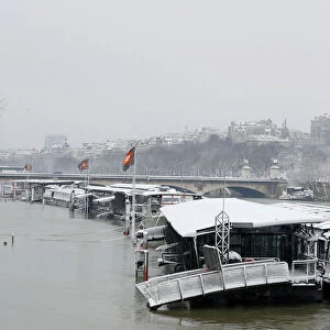 A view shows snow-covered peniche boats moored along the flooded banks of the River Seine