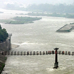 Visitors cross a cable bridge over Minjiang River in Chinas Dujiangyan