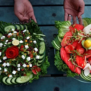 A waiter presents two types of salad served by Habibi restaurant in Peshawar
