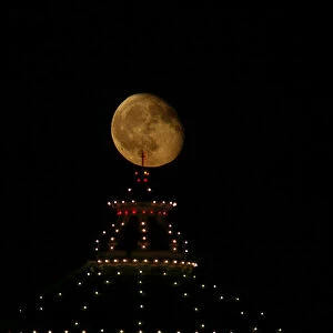 The waning gibbous moon rises behind the dome of the Church of the Assumption of Our Lady