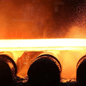 Water and steam fly off of a slab of steel rolls down the line at the Novolipetsk Steel