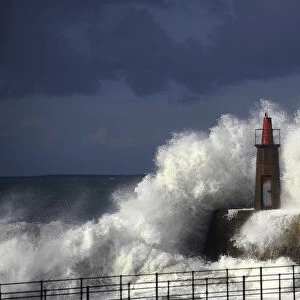 Waves crash against a lighthouse in Viavelez