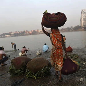 A woman carries sacks of leaves, which will be used to decorate flower bouquets, to