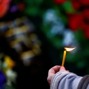 A woman holds a candle during an opposition rally to mark the anniversary of A woman holds a candle during an opposition rally to mark the anniversary of