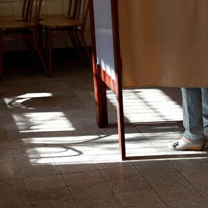 A woman stands in polling booth during Hungarian parliamentary elections at a polling