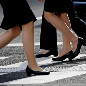 Women in high heels walk at a business district in Tokyo