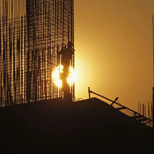 A worker arranges steel structures at construction site of apartment in Hanoi