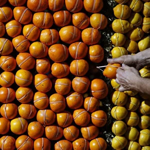A worker puts the final touches to a pattern made with lemons and oranges during the