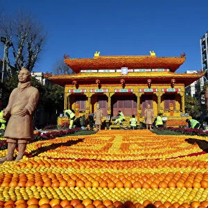 Workers put the final touches to a replica of the Forbidden City made with lemons