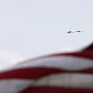 World War II era planes fly over U. S. flag during ceremony to commemorate the 70th