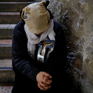 A worshipper rests in the Church of the Holy Sepulchre during a Good Friday procession
