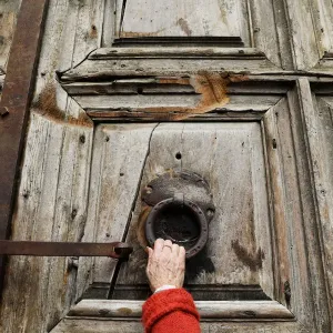 A worshipper touches the closed doors of the Church of the Holy Sepulchre in Jerusalem s A worshipper touches the closed doors of the Church of the Holy Sepulchre in Jerusalem s