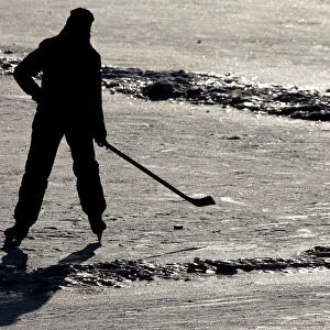 A young boy enjoys playing ice hockey on the frozen Vltava river in Prague