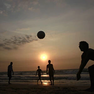 Youths play volleyball on the beach in Colombo